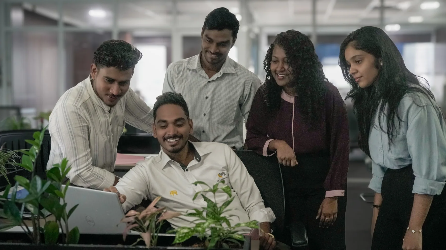 ILM Holdings team gathered around a colleague's desk in the Colombo office