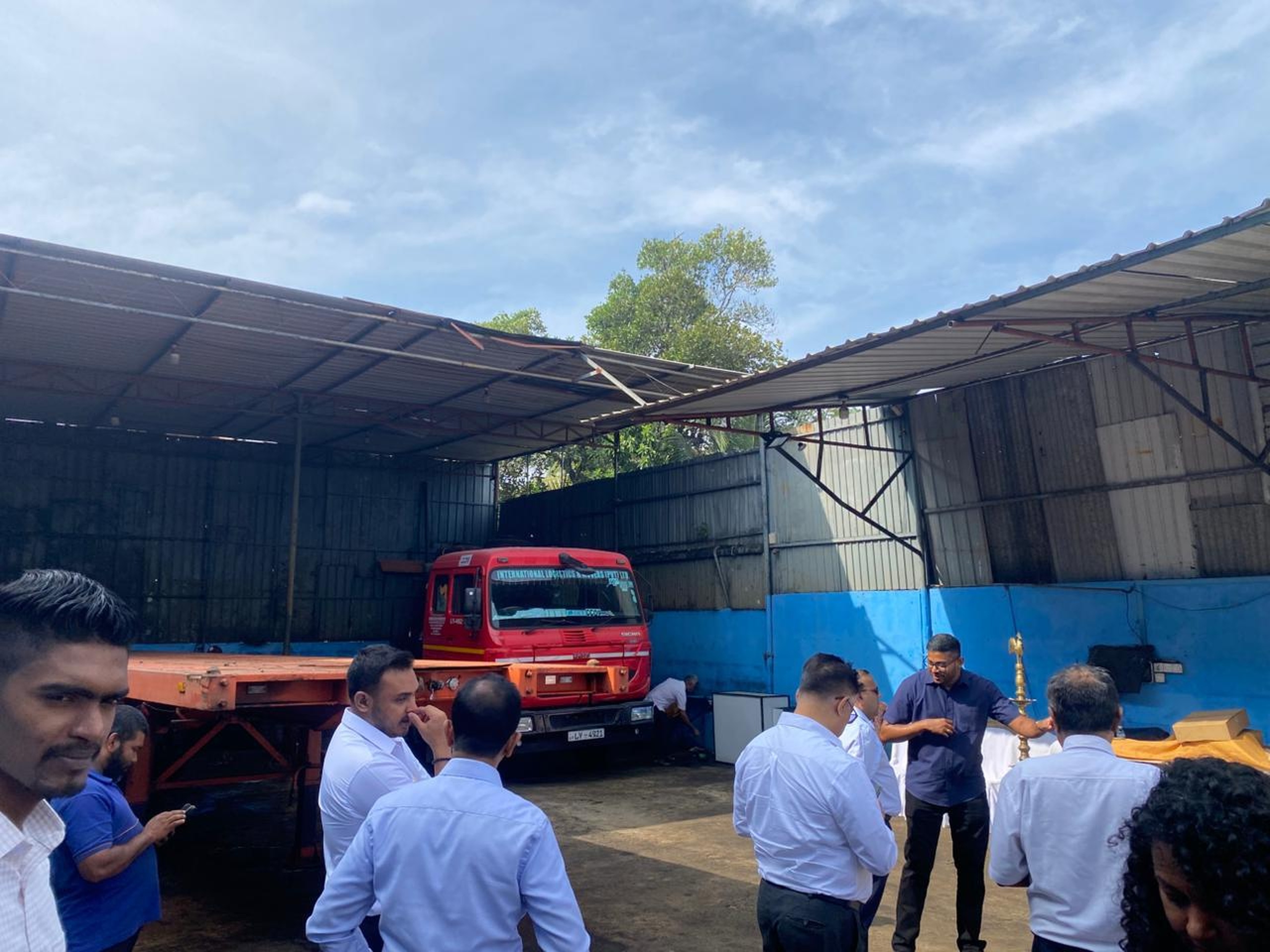 Management gathered at the transport yard beside an International Logistics prime mover