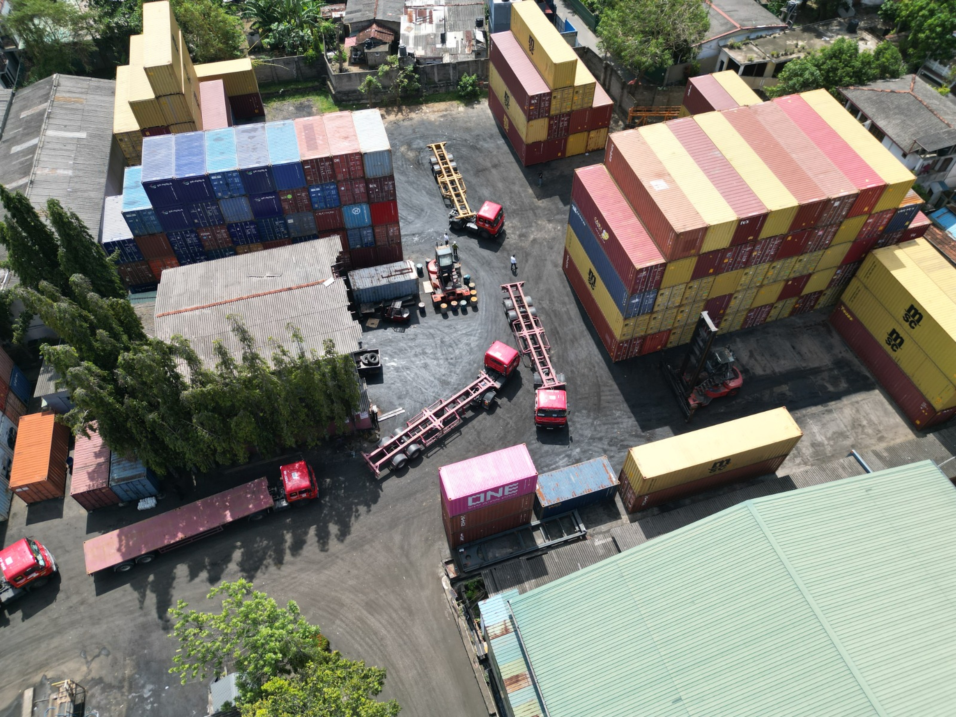 Aerial view of a container depot with stacked boxes, trailers and reach stackers