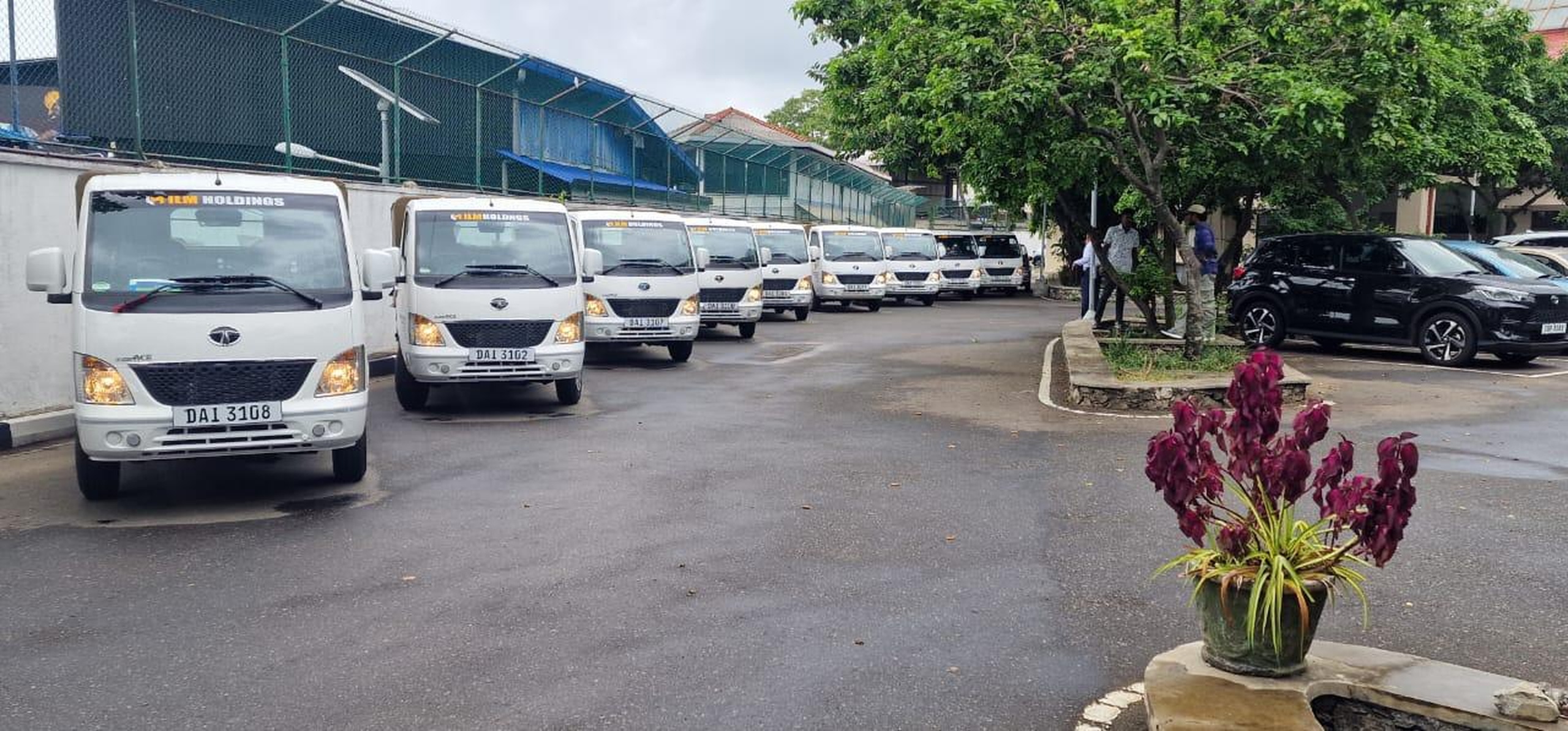 Line of white ILM Holdings Tata Ace light trucks parked in the yard