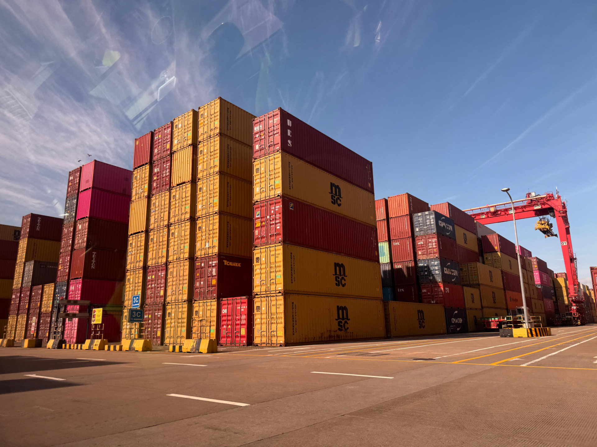 Stacks of shipping containers in the terminal yard at golden hour