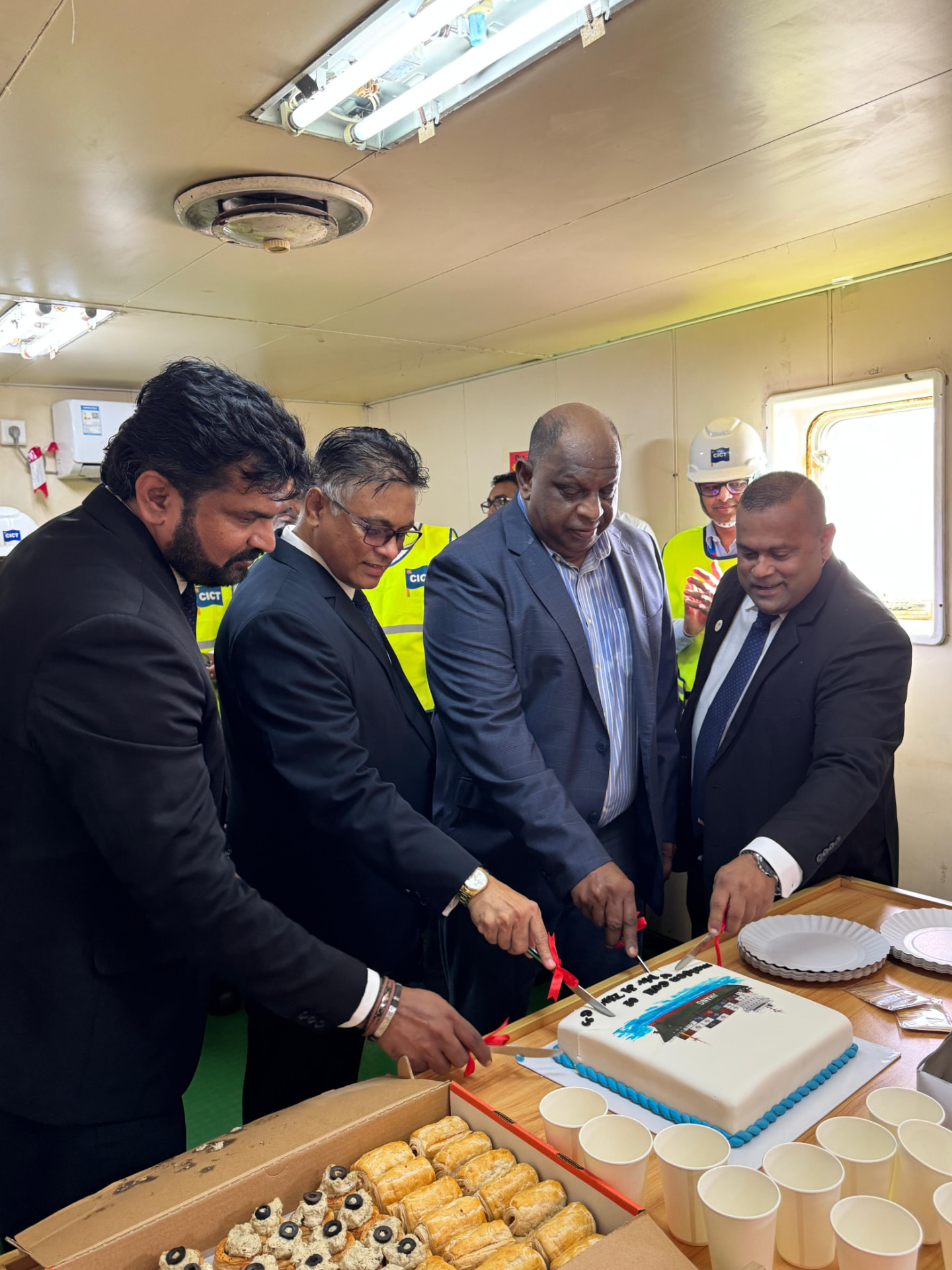 OCL and terminal representatives cutting a celebration cake on board a vessel