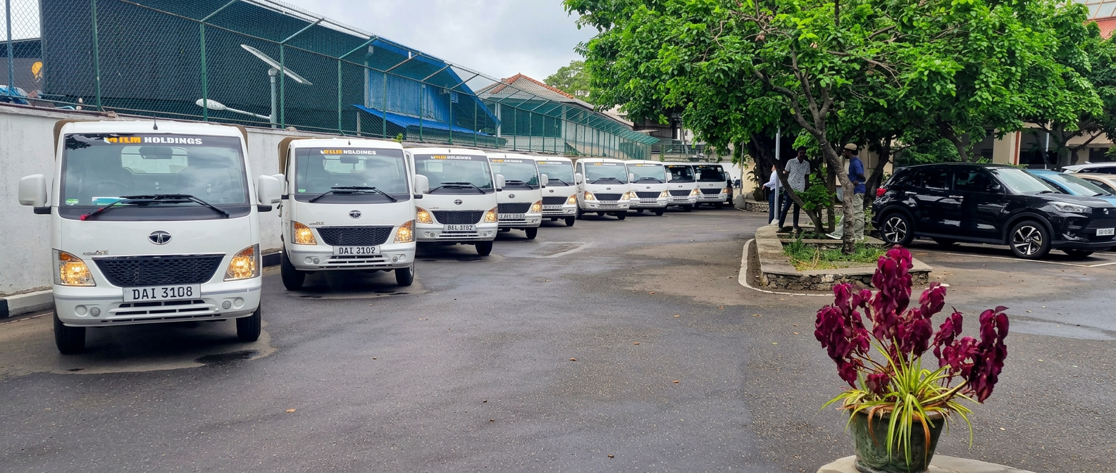 Line of white ILM Holdings light trucks parked at the yard