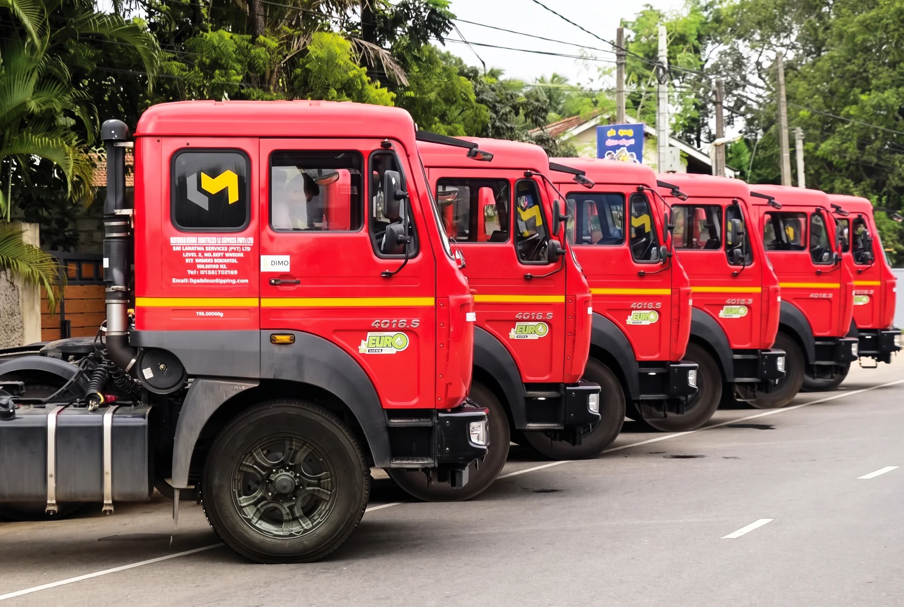 Row of red International Logistics & Movers prime movers lined up on the road